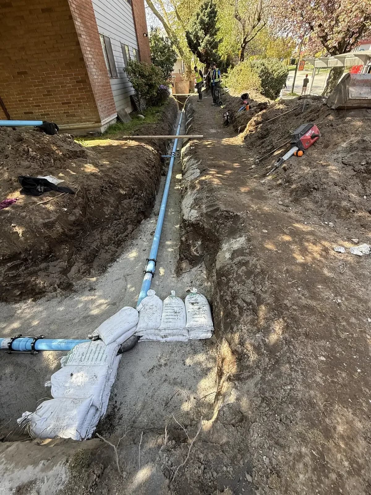 New underground water service installed beside a multi-unit building