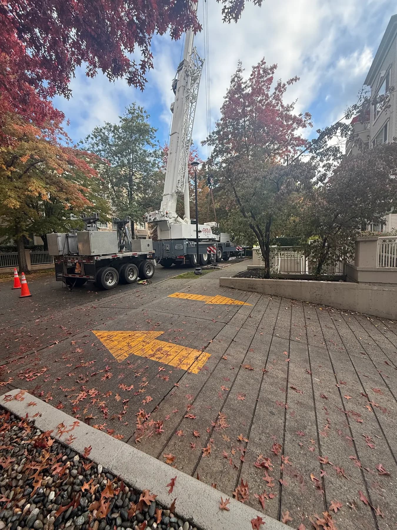 Crane staged for rooftop mechanical work at a residential property