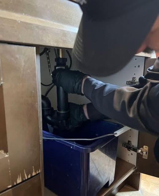 Under-sink plumbing service in progress